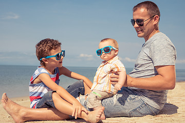 Image showing Father and children  playing on the beach at the day time.