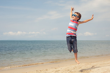 Image showing One happy little boy playing on the beach at the day time. 