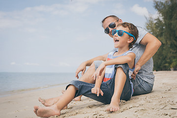 Image showing Father and son  playing on the beach at the day time.