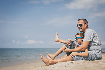 Image showing Father and son  playing on the beach at the day time.