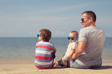 Image showing Father and children  playing on the beach at the day time.