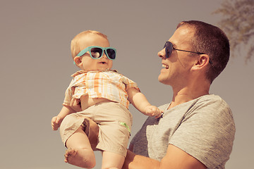 Image showing Father and baby son playing on the beach at the day time.