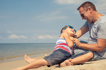 Image showing Father and son  playing on the beach at the day time.