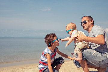 Image showing Father and children  playing on the beach at the day time.