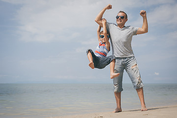 Image showing Father and son  playing on the beach at the day time.