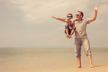 Image showing Father and son  playing on the beach at the day time.