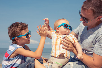 Image showing Father and children  playing on the beach at the day time.