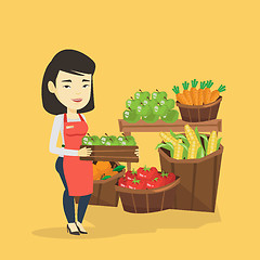 Image showing Supermarket worker with box full of apples.