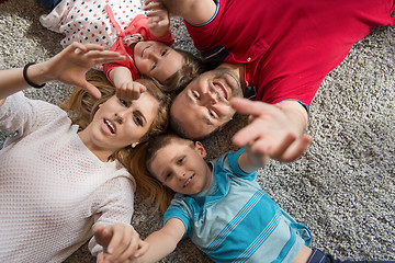 Image showing happy family lying on the floor