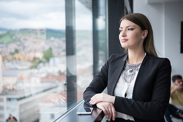 Image showing Elegant Woman Using Mobile Phone by window in office building