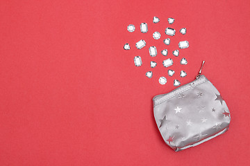 Image showing Silver purse and precious stones on bright pink background