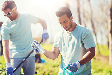 Image showing volunteers with garbage bags cleaning park area