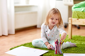 Image showing happy little girl with crayons drawing at home