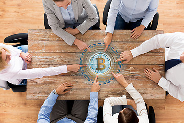 Image showing business team at table with bitcoin icon