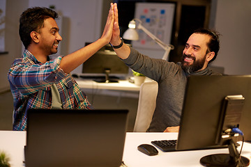 Image showing creative team making high five at night office