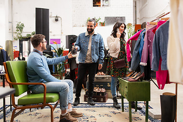 Image showing friends choosing clothes at vintage clothing store