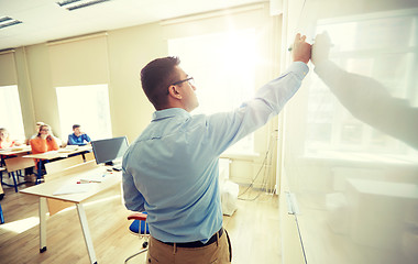 Image showing students and teacher writing on school white board