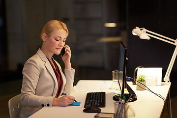 Image showing businesswoman calling on sartphone at night office