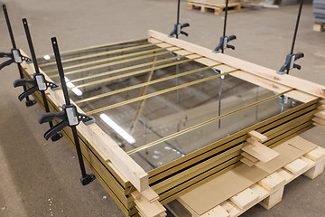 Image showing mirror panels with bar clamps at furniture factory