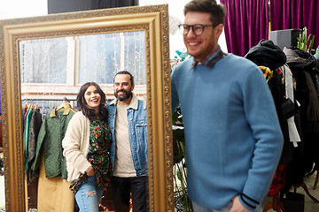 Image showing happy friends at mirror at vintage clothing store