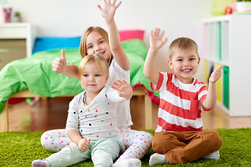 Image showing group of happy kids sitting on floor at home