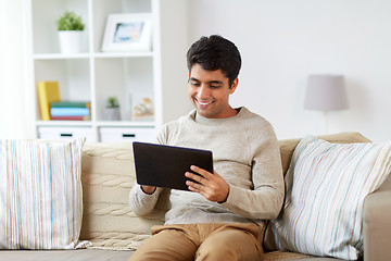 Image showing smiling man with tablet pc at home