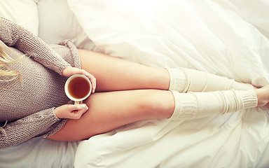 Image showing close up of woman with tea cup in bed