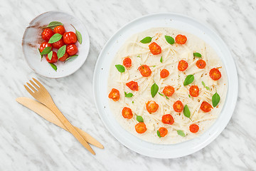 Image showing Preparing a tortilla with tomatoes, cheese and basil