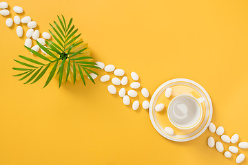 Image showing White chocolate, palm leaves and yellow teacup