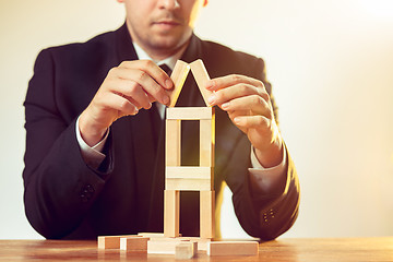 Image showing Man and wooden cubes on table. Management concept