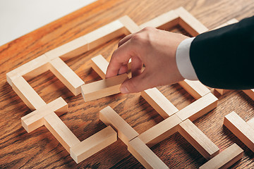 Image showing Man and wooden cubes on table. Management concept