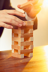 Image showing Man and wooden cubes on table. Management concept