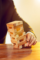 Image showing Man and wooden cubes on table. Management concept