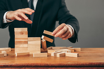 Image showing Man and wooden cubes on table. Management concept