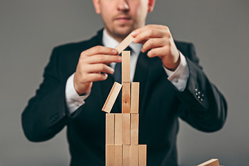 Image showing Man and wooden cubes on table. Management concept