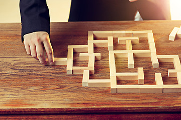 Image showing Man and wooden cubes on table. Management concept