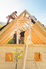 Image showing Builders at work with wooden roof construction.