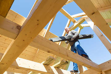 Image showing Builder at work with wooden roof construction.