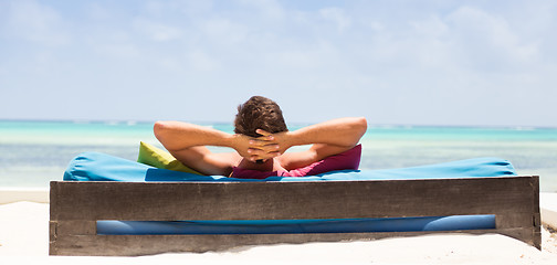 Image showing Relaxed man in luxury lounger enjoying summer vacations on beautiful beach.