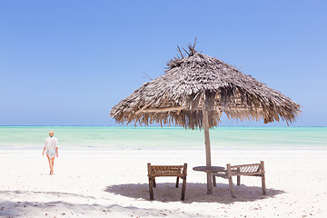 Image showing Lady walking to the sea oat white sandy tropical beach of Paje, Zanzibar, Tanzania.