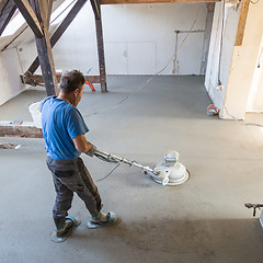 Image showing Laborer polishing sand and cement screed floor.