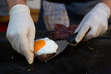 Image showing Chef making beef burgers outdoor on open kitchen international food festival event.