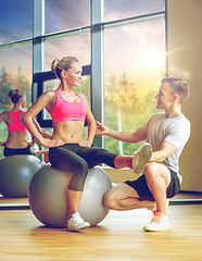 Image showing smiling man and woman with exercise ball in gym