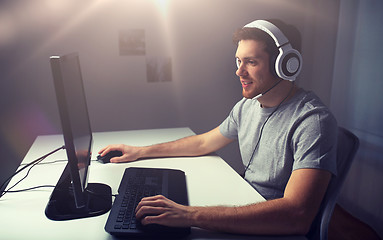 Image showing man in headset playing computer video game at home