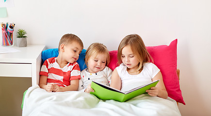 Image showing little kids reading book in bed at home