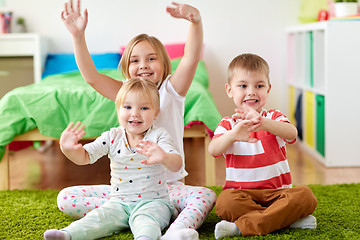 Image showing group of happy kids sitting on floor at home