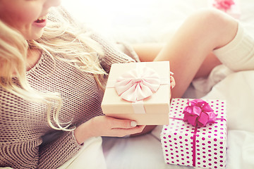 Image showing close up of woman with birthday gifts in bed