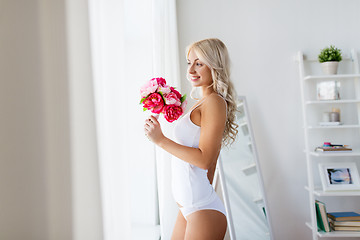 Image showing woman in underwear with bunch of flowers at window