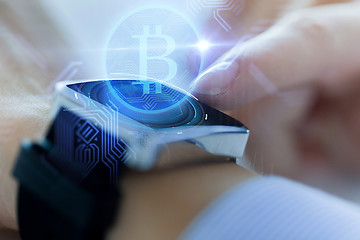 Image showing close up of hands with bitcoin on smart watch