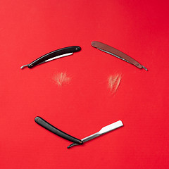 Image showing combs and hairdresser tools on red background top view